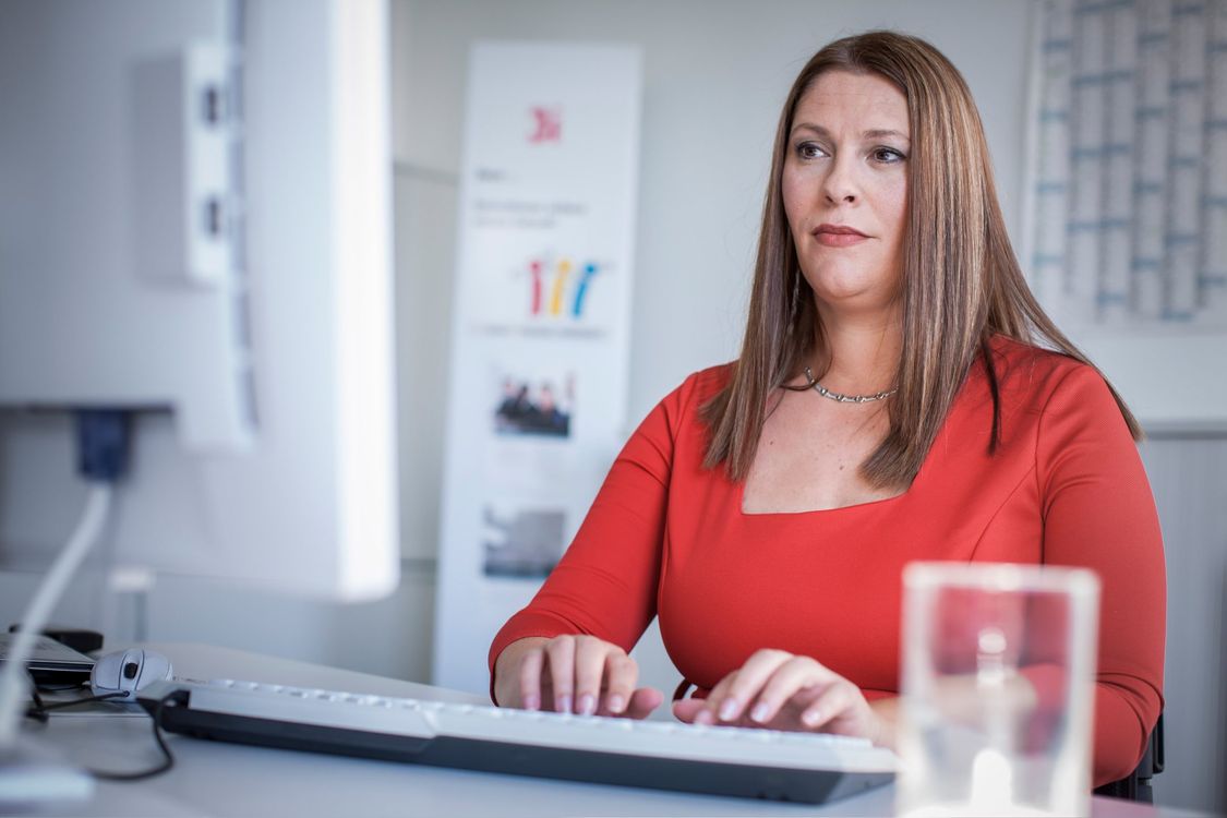 Marina sitzt am Schreibtisch und arbeitet an ihrem Computer