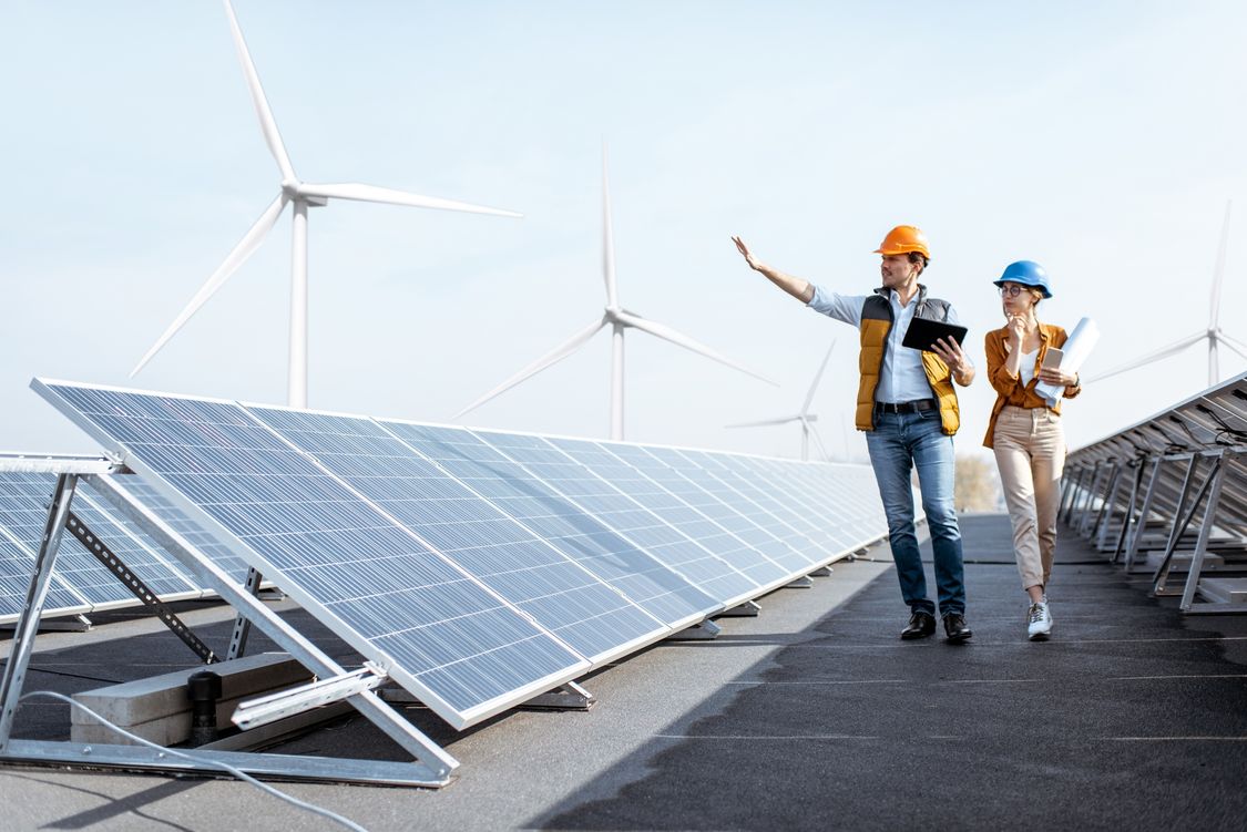 Siemens colleauges walking alongside solar array panels in hard hats