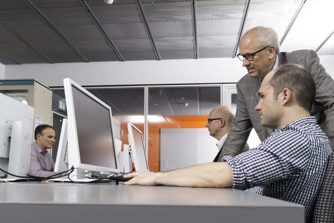Picture of people talking at a computer in a training session