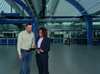Two professionals reviewing tablet in industrial facility
