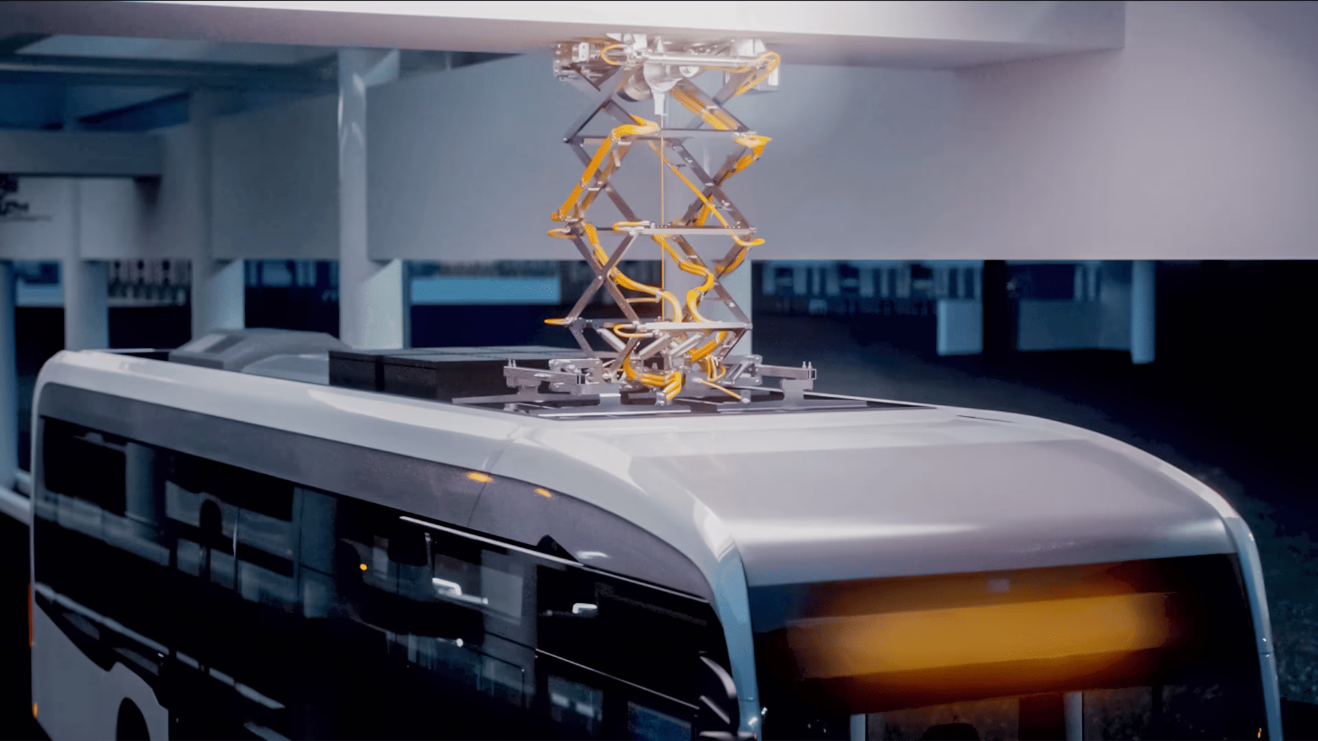 Ein E-Bus, der an einem Überkopf-Ladesystem in einer überdachten Bushaltestelle angeschlossen ist. siemens-mobility-indoor-bus-stops