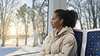 A young woman rides in a Siemens Mobility Inspiro Metro through a winter landscape in Oslo.