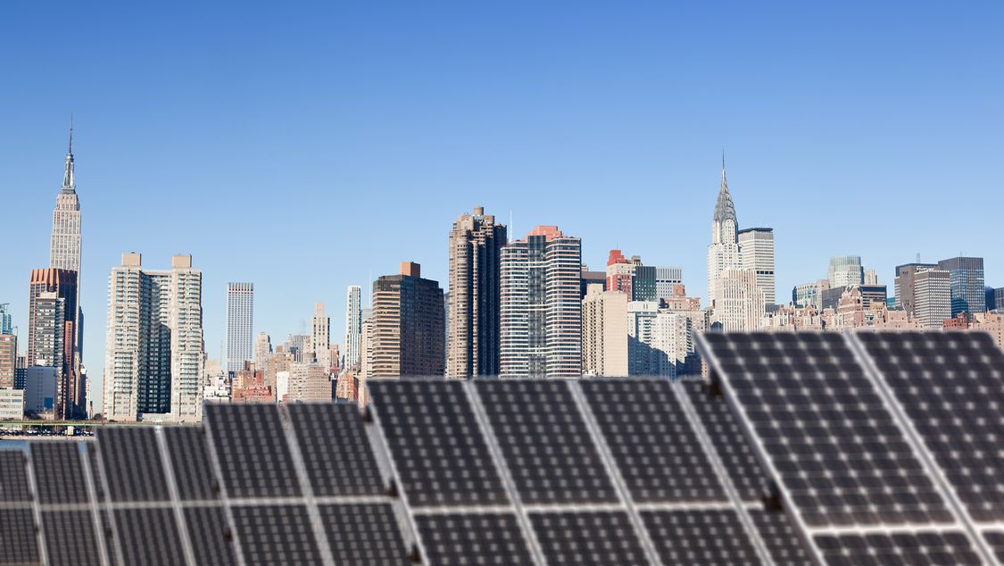 Installation solaire sur le toit avec vue sur Midtown Manhattan en arrière-plan, Chrysler Building et Empire State Building.