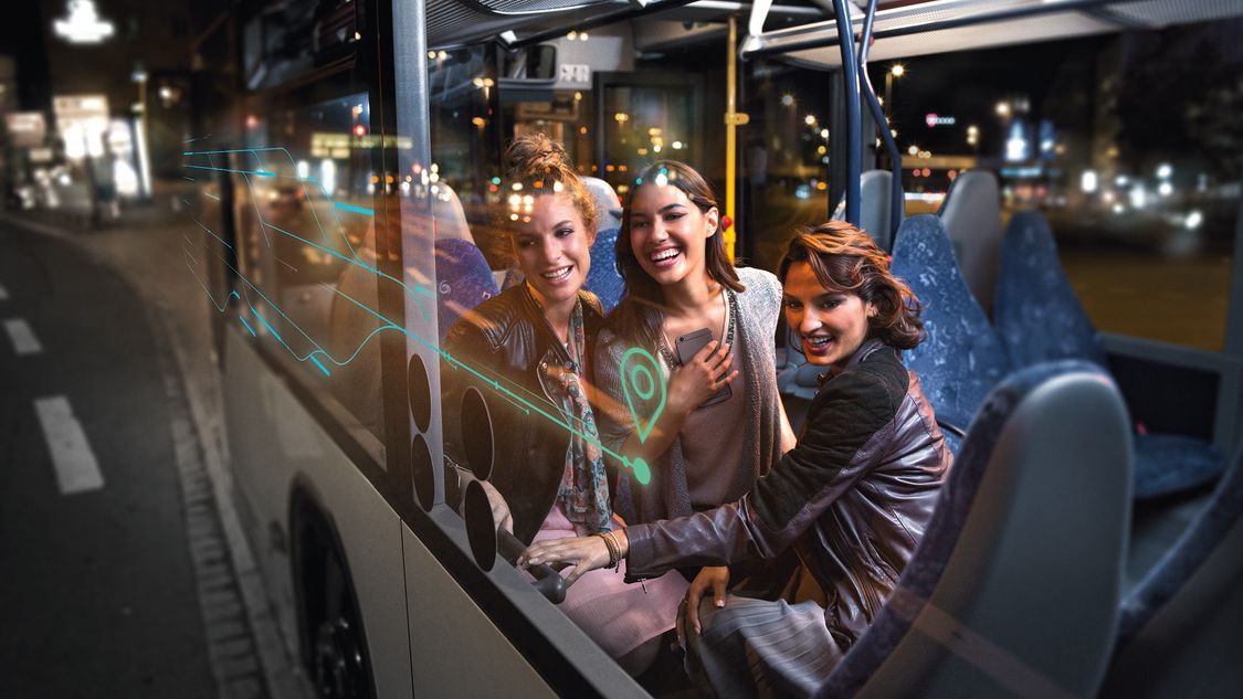 Happy young women on a bus at night