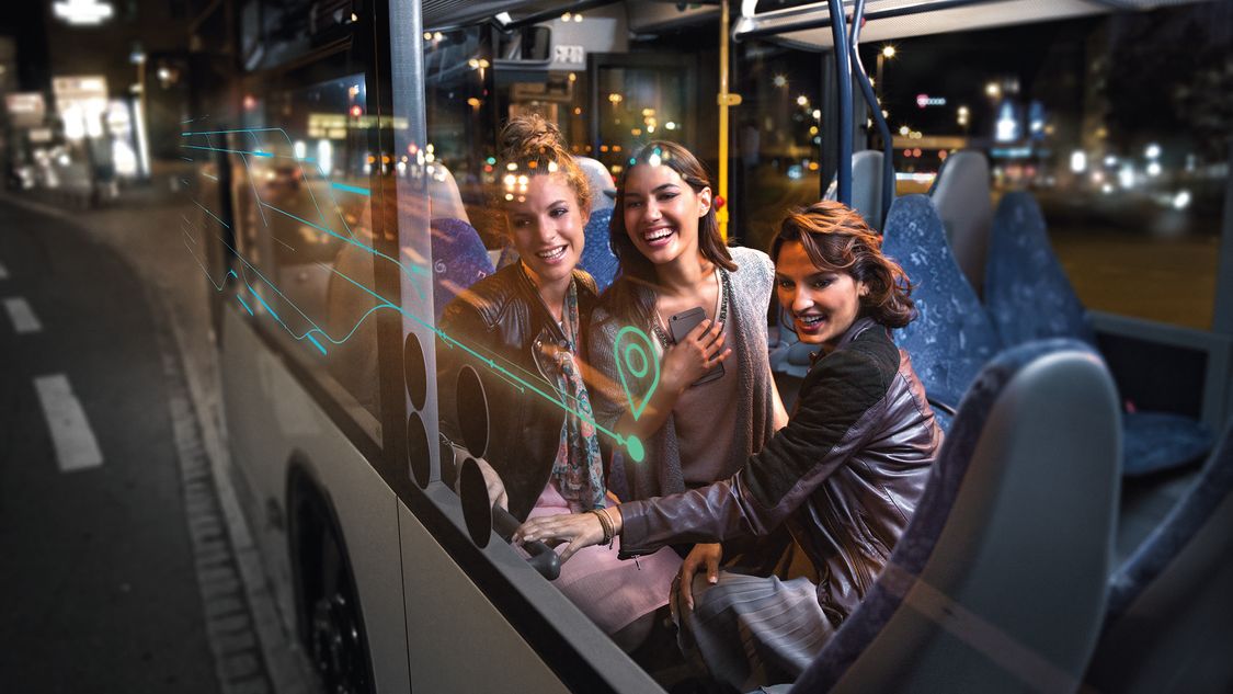 Three happy women on a bus at night