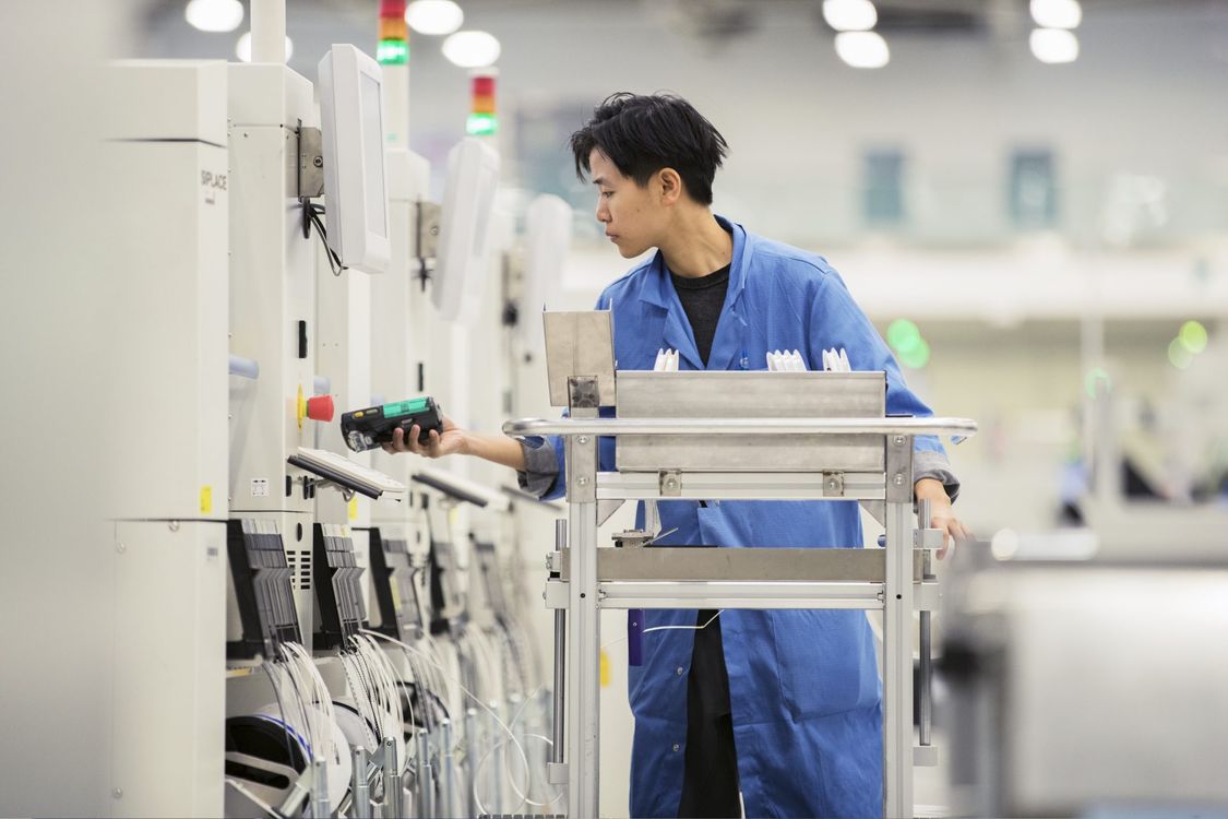  Operário chines usando jaleco azul fazendo vistoria em linha de produção na fábrica da siemens em chengdu, china