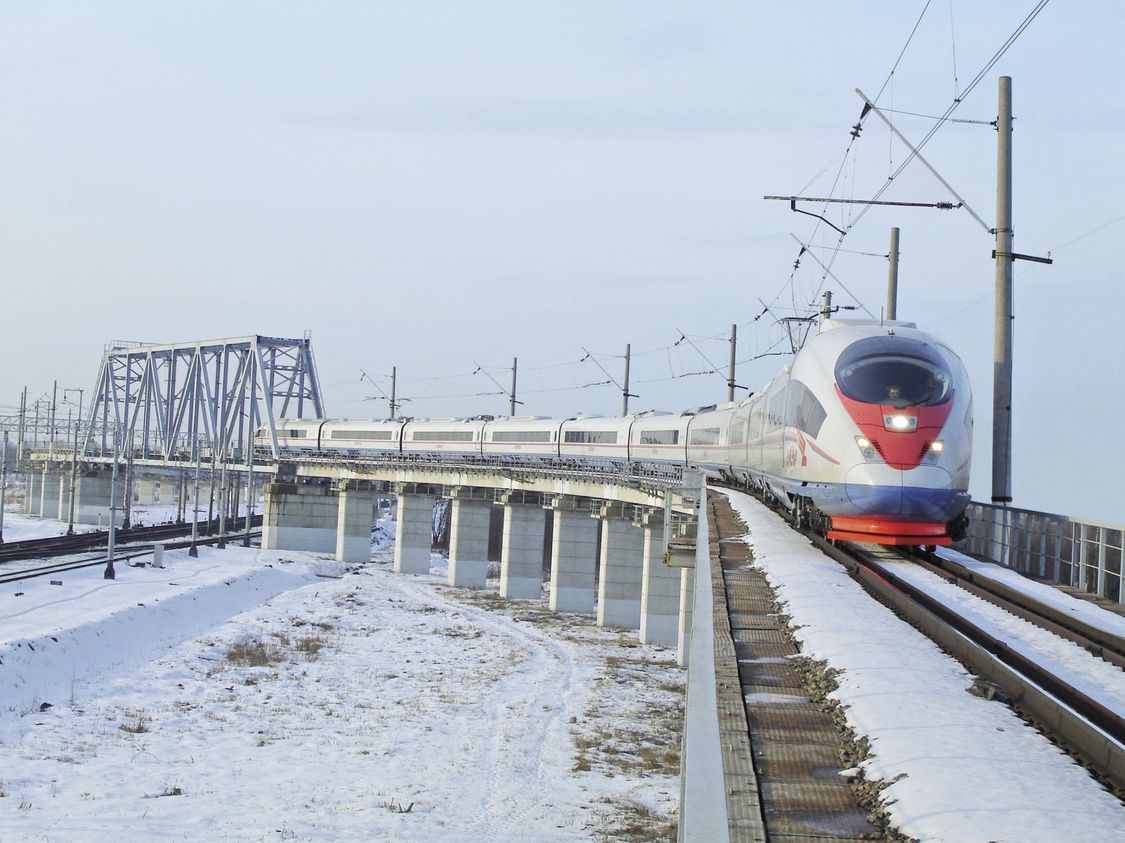 Picture of the Velaro RUS from Siemens Mobility driving over a snow-covered landscape.
