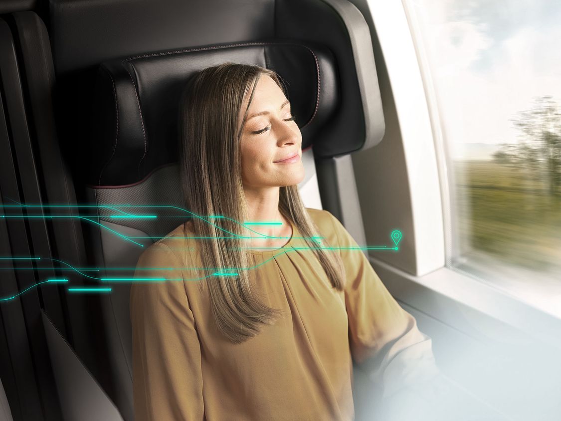 A passenger on a train enjoys an improved passenger experience with end-to-end journey touchpoints pictured using digital graphic elements