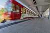 rotweisser Zug verlässt einen leeren Bahnhof