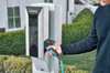 Image of a man taking the plug out of a VersiCharge charging station to charge his electric car