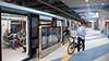 Ein Mann geht mit seinem Fahrrad an einem Bahnsteig in Sofia entlang und macht sich zum Einsteigen in die Siemens Mobility Inspiro Metro bereit.