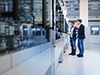 Mitarbeiter unterhalten sich in einer Anlage über Industrial Network Validation Mitarbeiter unterhalten sich in einer Anlage über Industrial Network Validation
