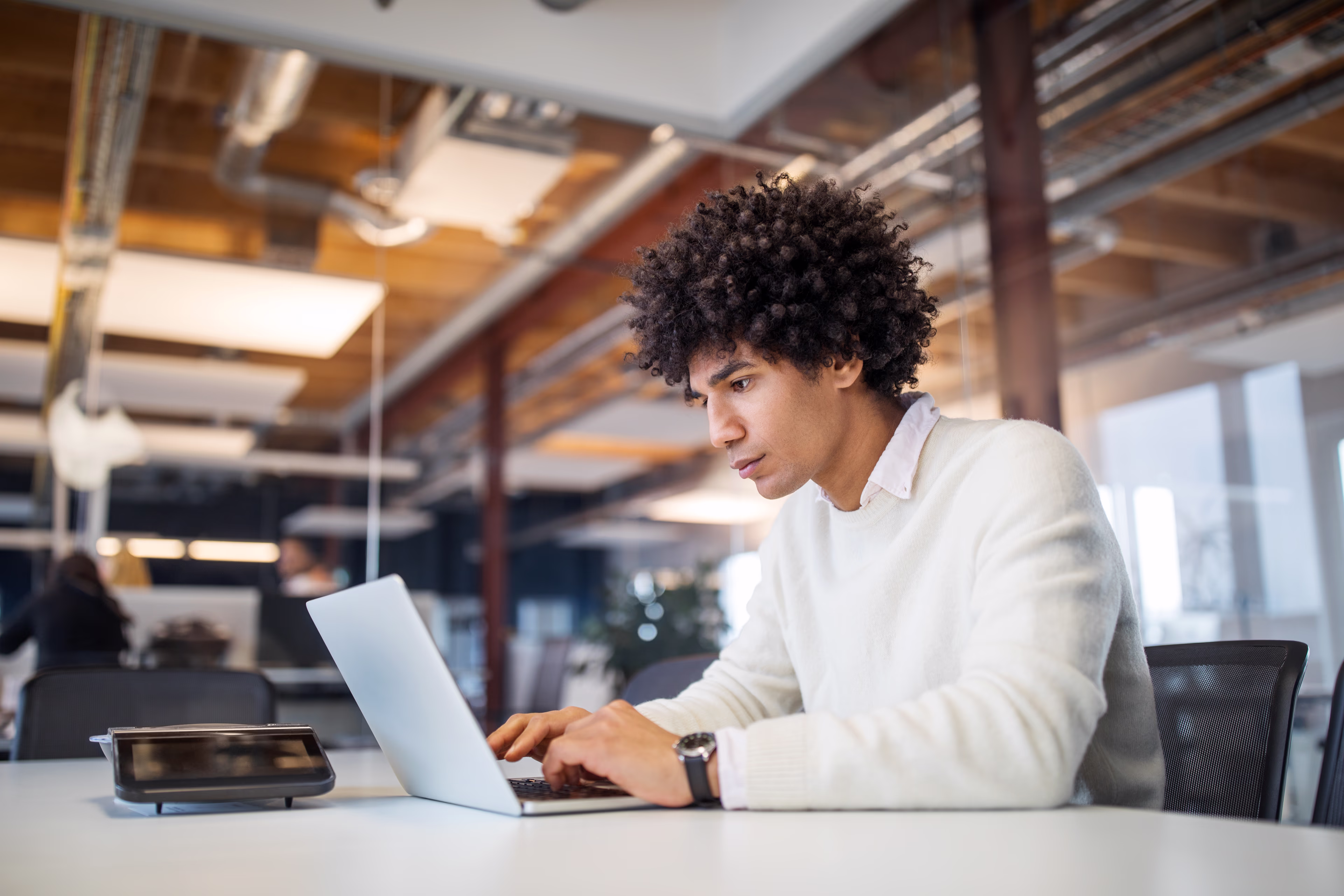 Man in a modern office environment working on a laptop Man in a modern office environment working on a laptop