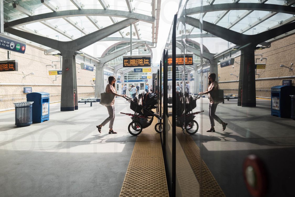 Women walking baby stroller onto a train  