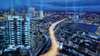 Imagem aérea de uma cidade grande com fluxo de luzes dos carros representando as soluções de média e baixa tensão da siemens