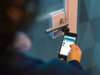 Person using smartphone app near door handle Person using smartphone app near door handle