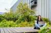 Student sitting on a bridge studying at college Siemens Campus Sustainability