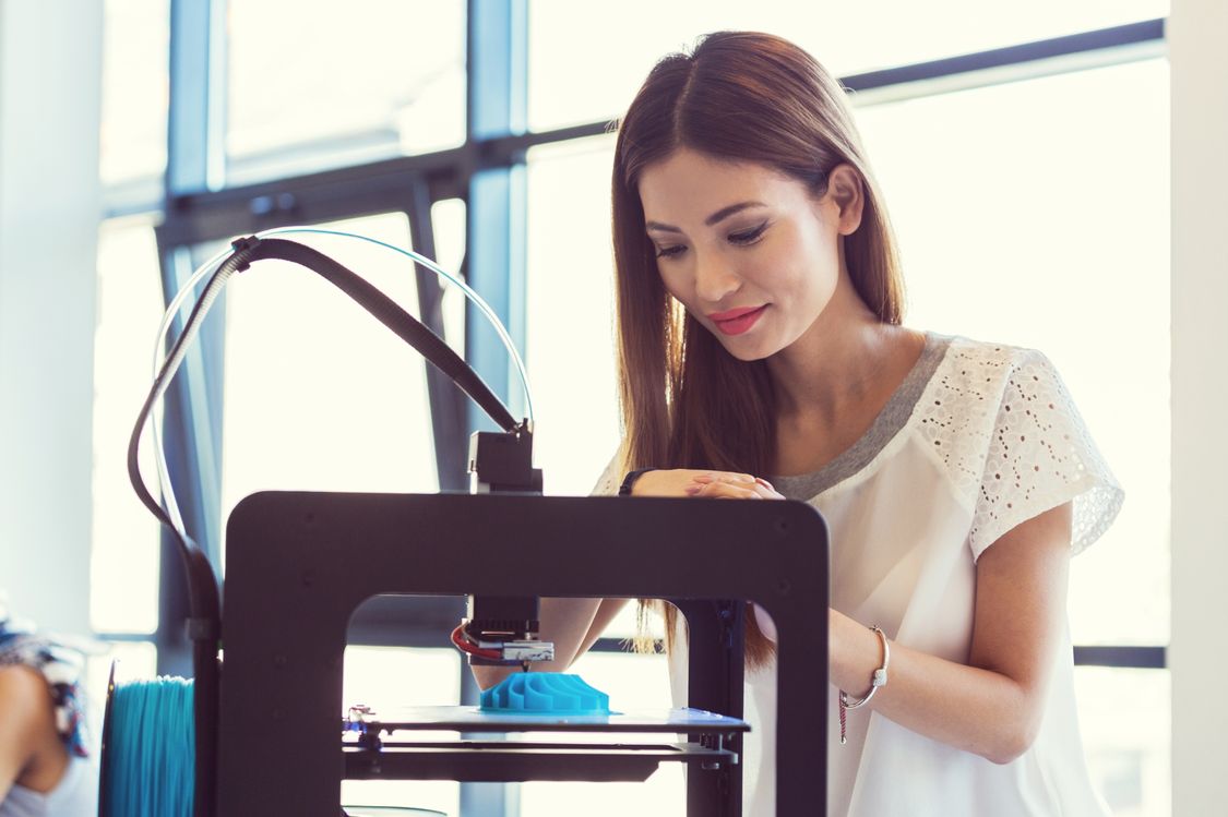 en kvinna använder 3D-skrivare och tittar på 3D-utskrift