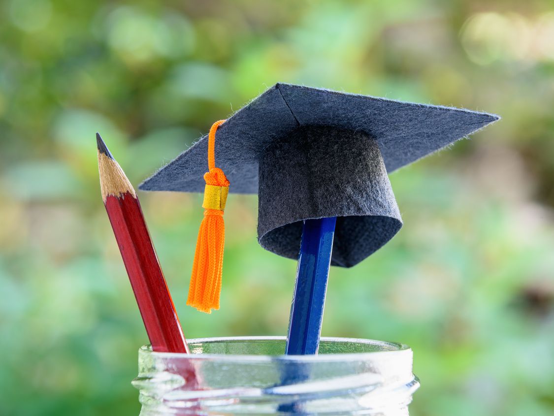pencils in a cup with graduation cap