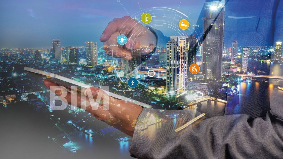 Building Information Modeling represented by a glass pane through which buildings can be seen and as a reflection a hand with tablet