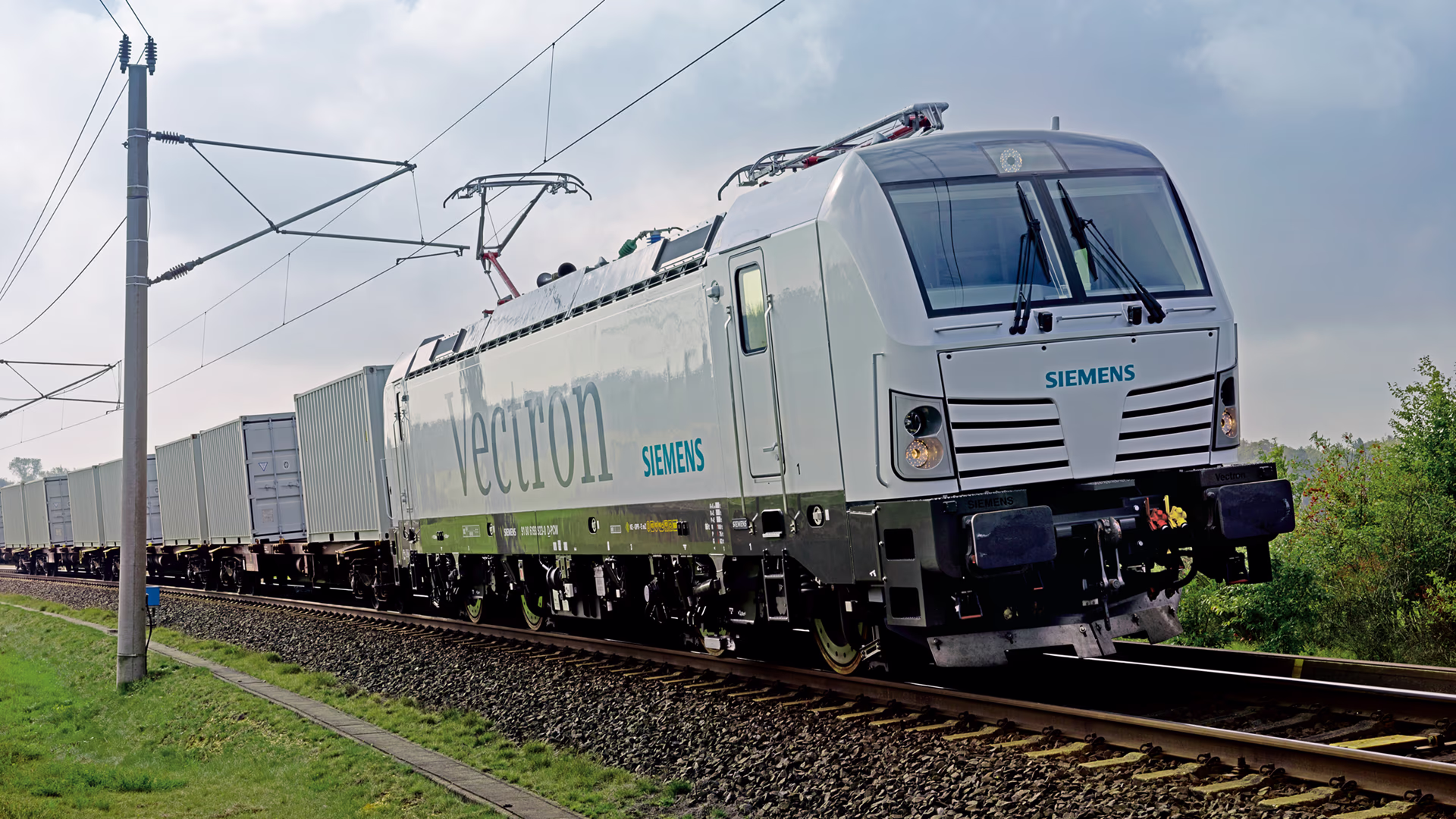 Vectron Dual Mode locomotive riding through a green field. Vectron Dual Mode locomotive riding through a green field.