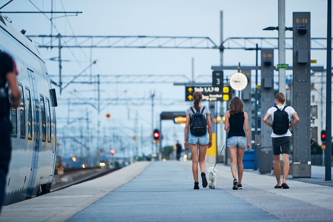People walking on an outdoor train platform 