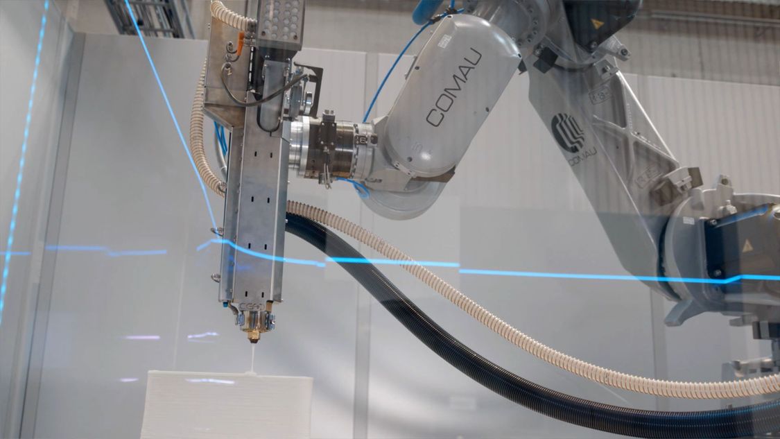 Photo of a Comau robot arm with additive manufacturing tool head