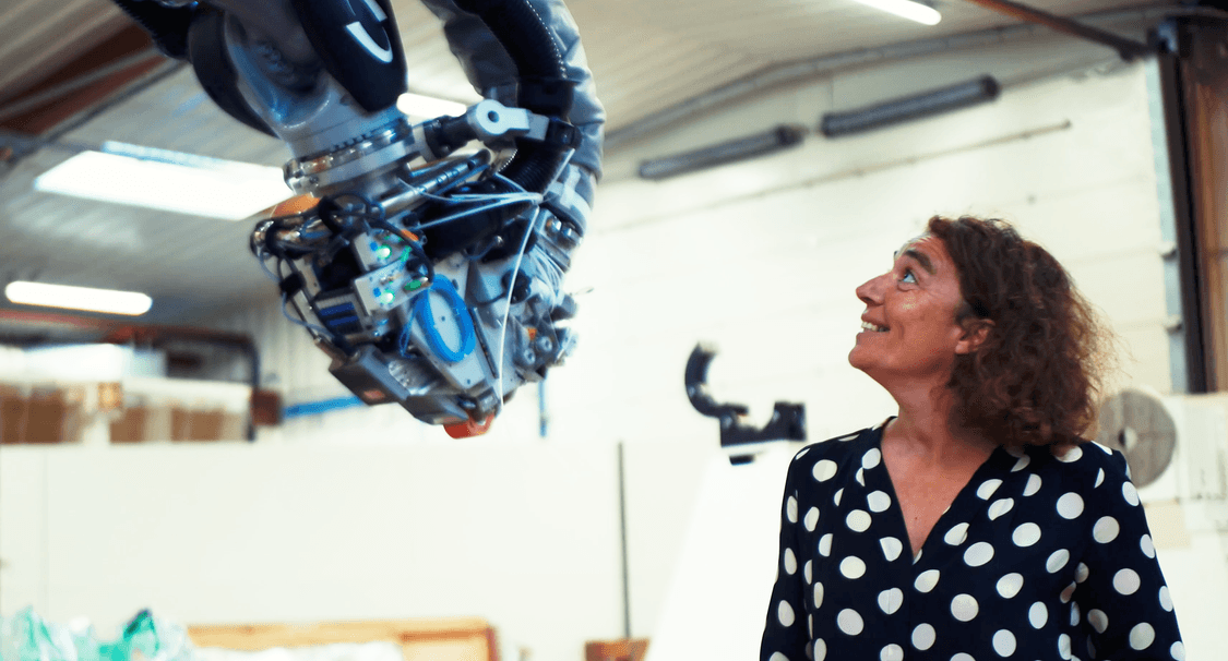 Clémentine Gallet fondatrice de Coriolis Composites souriant face à la tête de son robot