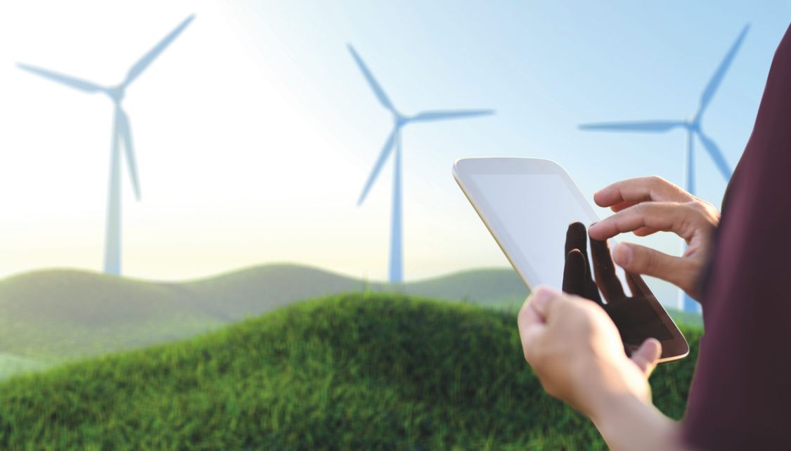 An engineer using a tablet to operate the wind turbine.