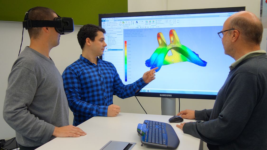 Utz Wever (rechts) und zwei Kollegen aus der Vorfeldforschung für Simulationsinnovationen testen und diskutieren ihre Arbeitsergebnisse.