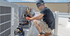 HVAC technician working on a rooftop unit.