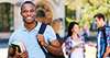 Smiling student with books and backpack on campus student-with-backpack