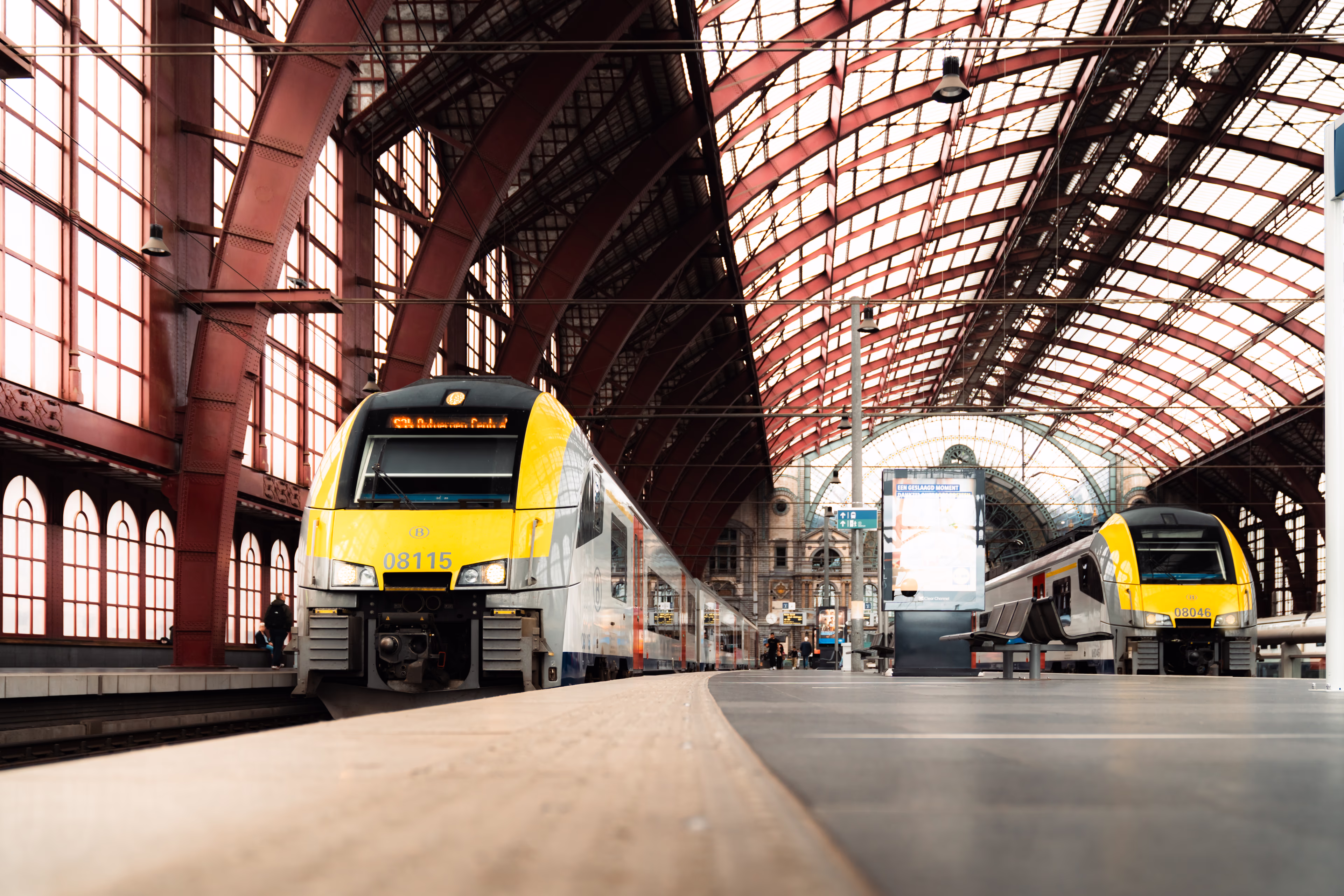 Yellow trains at ornate station with arched glass ceiling desiro-antwerpen-centraal