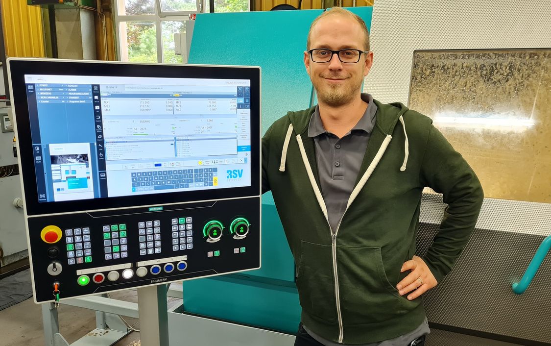 Photo with Philipp Reichmann, group leader at Forschner, at the control panel of the revised machine.