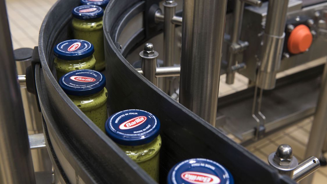 Jars of pesto roll off the production line at Barilla‘s sauce plant