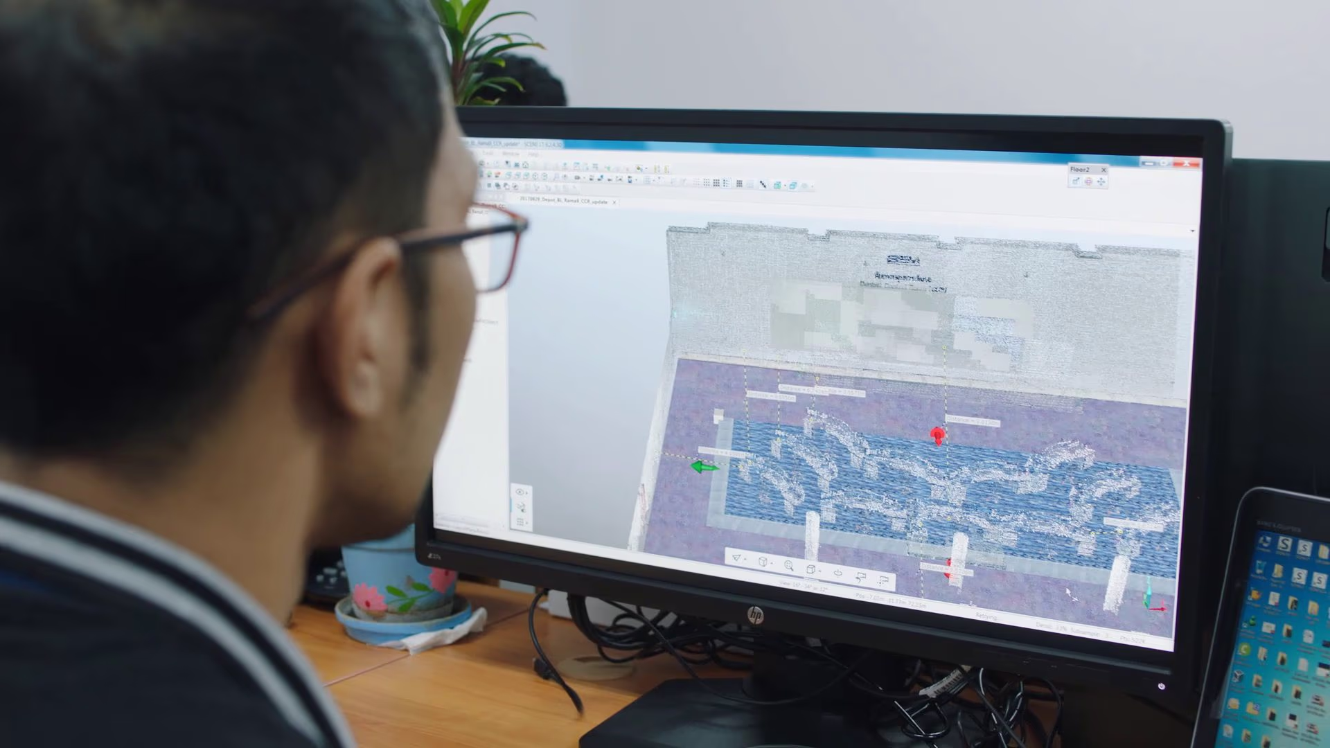 Ein Experte prüft ein 3D-Model eines Betriebszentrums im Computer Digitaler Zwilling mit Building Information Modeling (BIM)