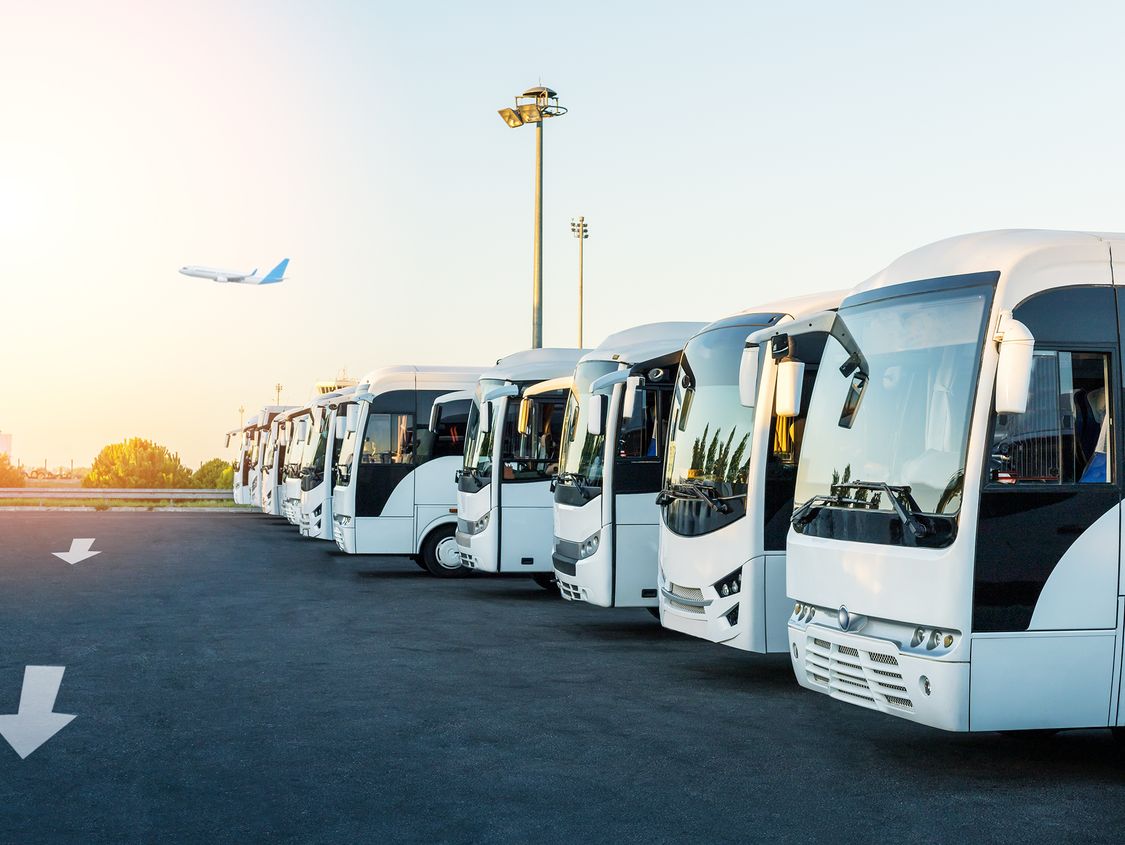 Row of electrified shuttle buses at an airport