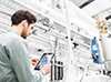 Specialist in a manufacturing plant checks plant data on his iPad Specialist in a manufacturing plant checks plant data on his iPad