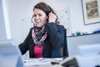 Christina sitzt mit einem Headset am Schreibtisch