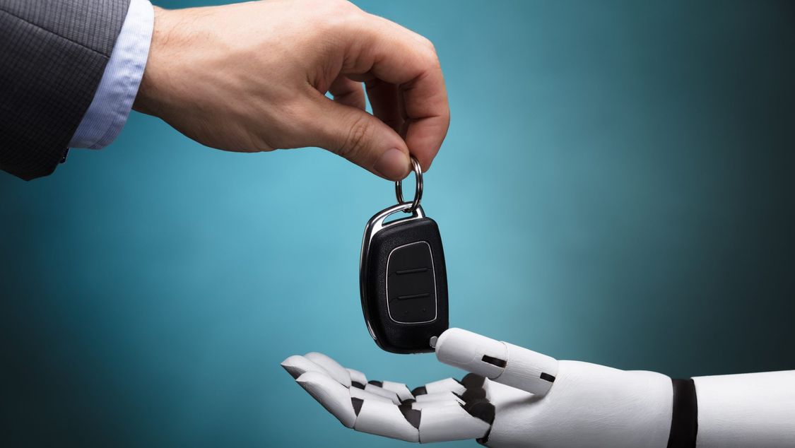 mão de um humano entregando uma chave para um mão de um robô