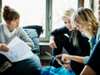 Three women collaborating, reviewing documents and tablet upskilling-for-transformation